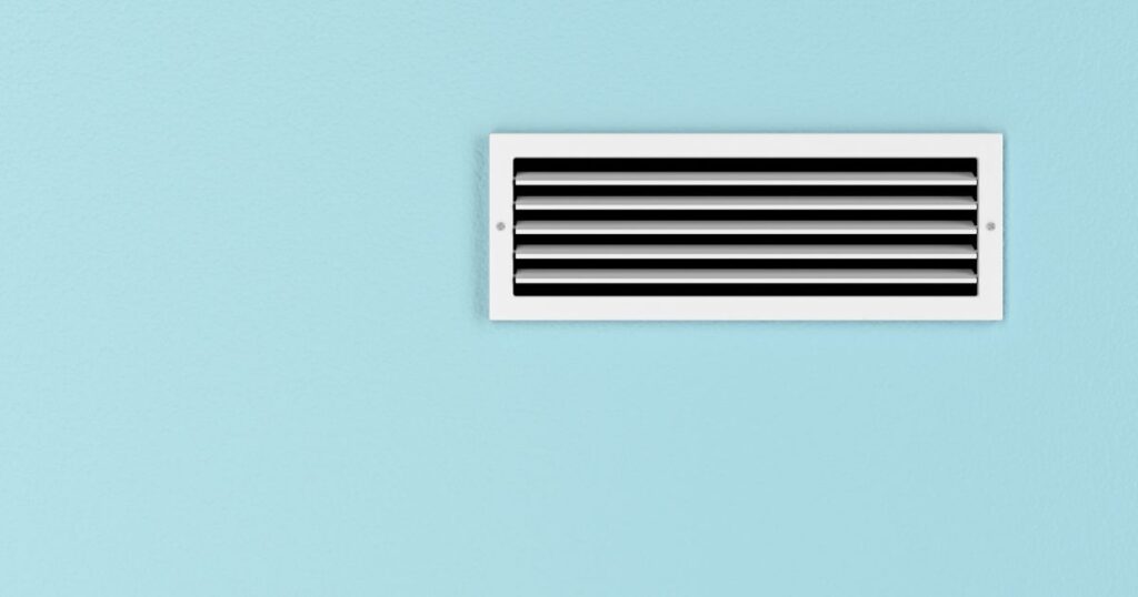 An air vent on a powder blue wall.